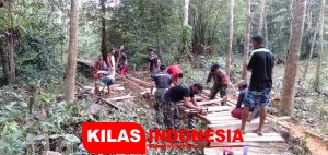 Bersama Warga, Prajurit Satgas Yonif 642 Perbaiki Jembatan Rusak